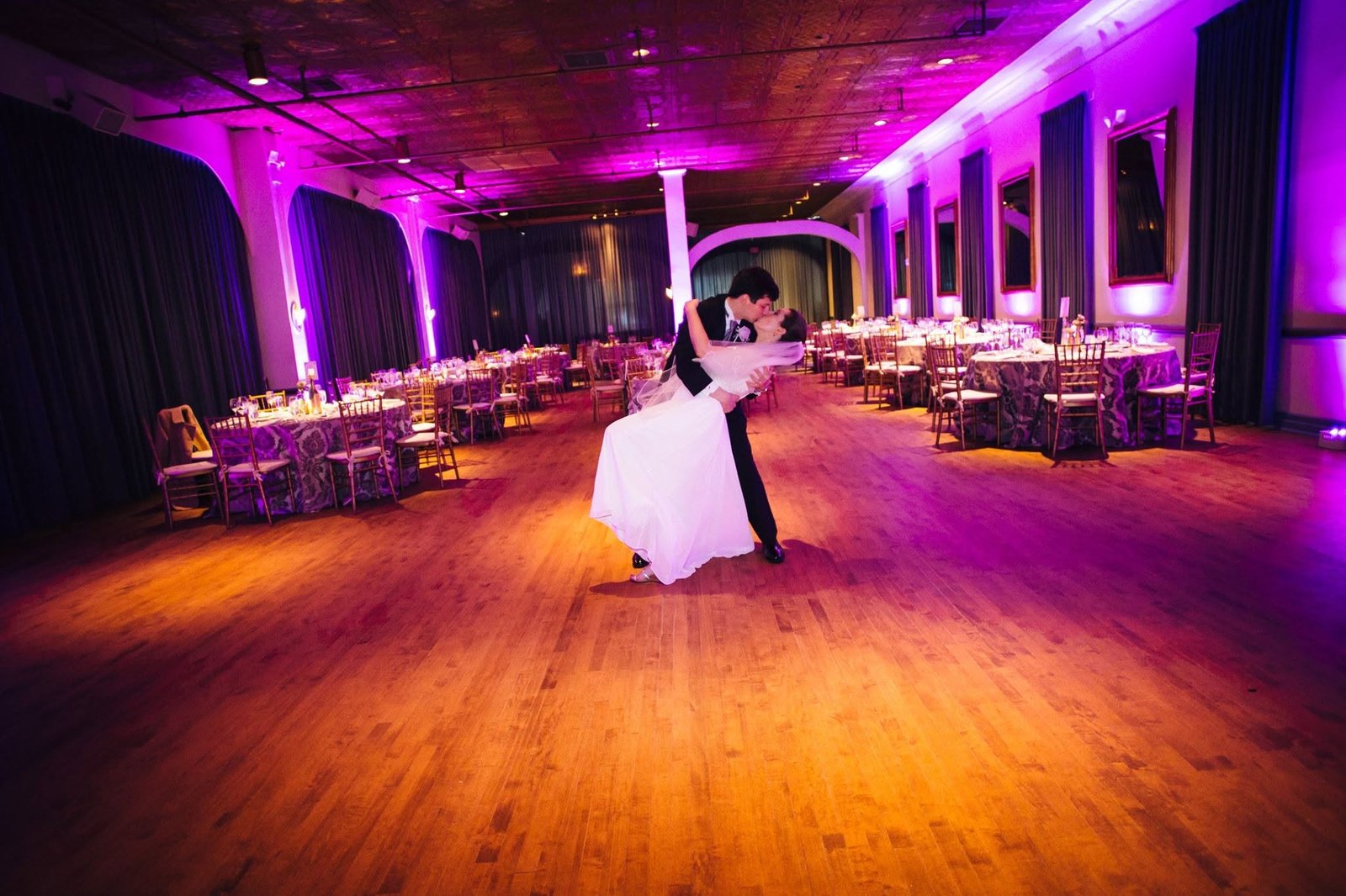 A newly married couple share a dramatic dip and kiss on the dance floor
