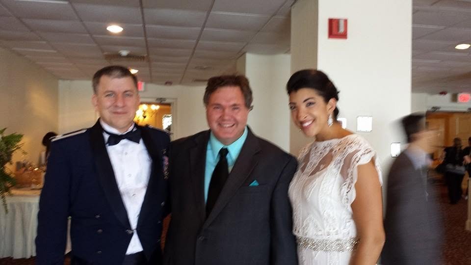Ed sharing a warm moment with the newlyweds and a guest at a reception