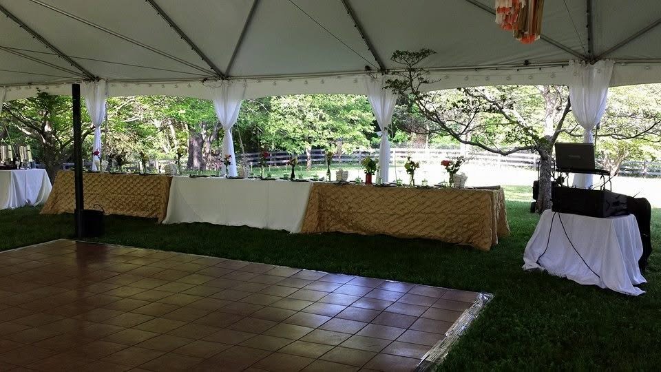 Wedding reception dance floor set up under a tent with DJ booth
